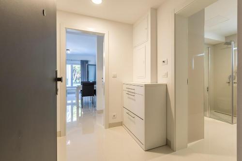 a kitchen with white cabinets and a view of a table at Villa Sky in Mimice