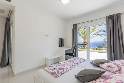a bedroom with a bed and a large window at Villa Sky in Mimice