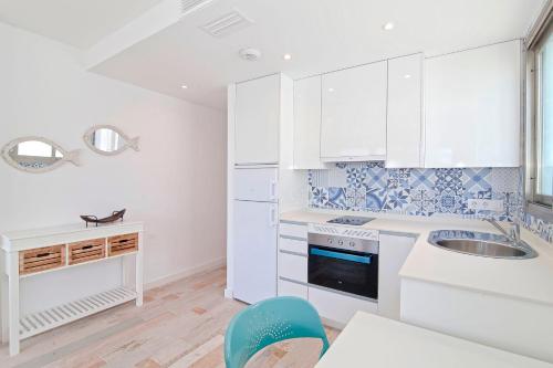 a kitchen with white cabinets and a sink at Apartments Beach 4U - Can Pastilla in Can Pastilla