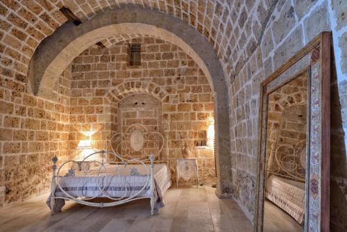 Un dormitorio con una cama en una pared de ladrillos. en B&B Masseria Conti Filo, en Altamura