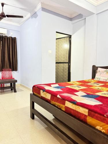 a bedroom with a bed with a colorful quilt at Saichha Guest House in Calangute
