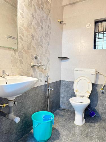 a bathroom with a white toilet and a sink at Saichha Guest House in Calangute