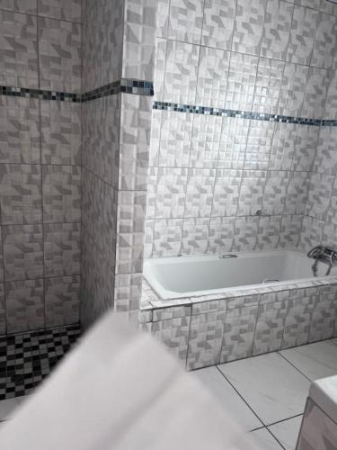 a white bathroom with a tub and a sink at Rio Lodge in Butterworth