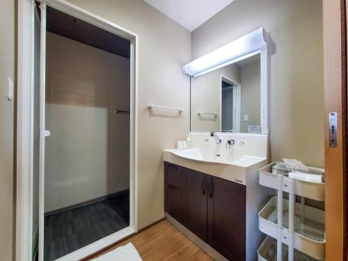 a bathroom with a sink and a mirror at Shichi no Hotel in Shichigahama