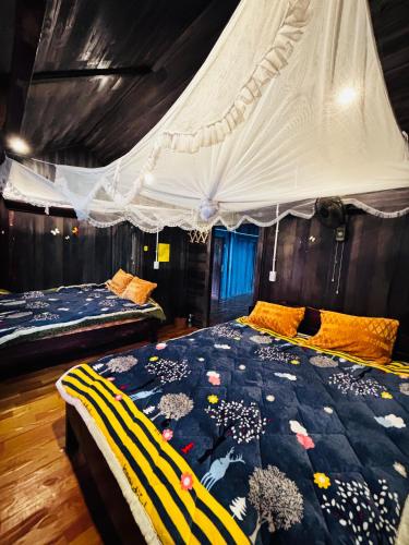a bedroom with two beds and a canopy at Sisi House Experience Hike & Batik Painting in Sa Pả