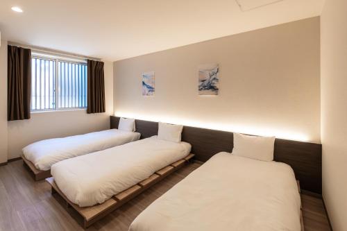 a room with three beds in it at ReLA Kashiwa Eki Mae in Kashiwa