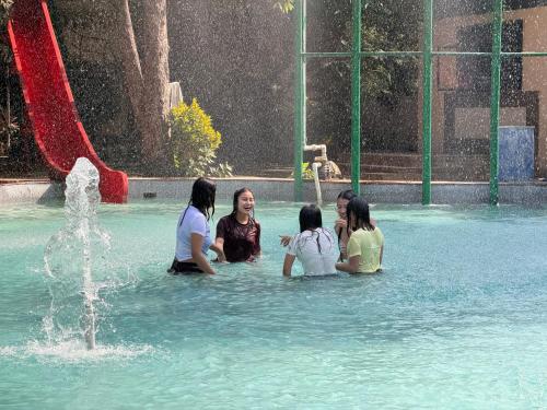 a group of people sitting in the water in a fountain at Aayush Resort Karjat in Kālundri