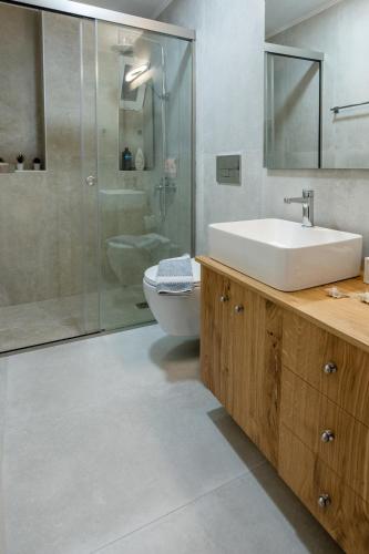 a bathroom with a sink and a shower and a toilet at Blue wave in Ierapetra