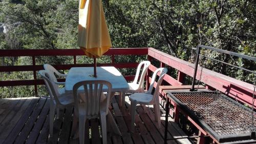 a table and chairs with an umbrella on a deck at Cabaña El Ingenio in El Ingenio