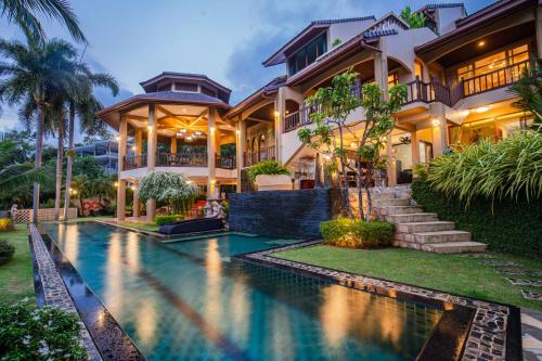 a house with a swimming pool in front of it at Bell Seaside Luxury Villa in Rawai Beach