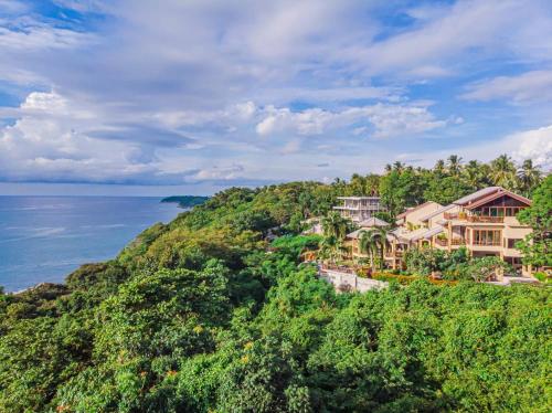 an aerial view of a house on a hill next to the ocean at Bell Seaside Luxury Villa in Rawai Beach