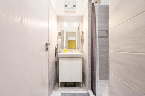 a white bathroom with a sink and a mirror at happy home JOY - apartment with free Pinball Machine in Budapest