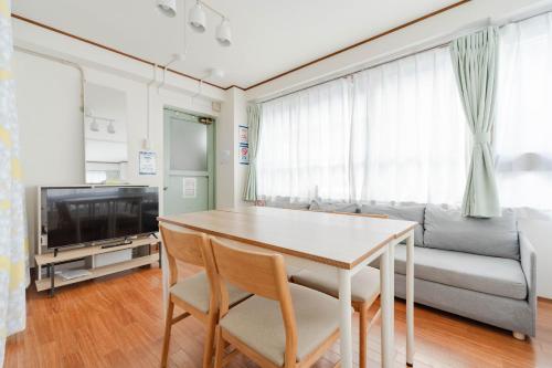 a living room with a table and a couch at Large Private House for 18 Tokyo Tower JR Hamamatsucho 8min HOTEL Musashi Tokyo Shiba in Tokyo