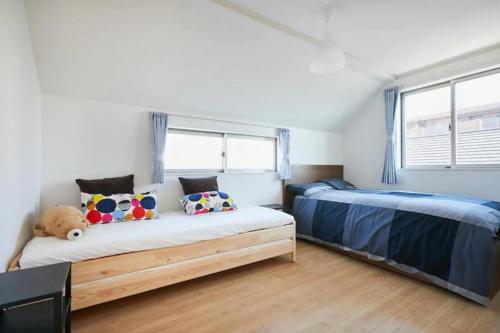 a bedroom with two beds and a large window at koiwa house 3LDK free wifi free parking in Tokyo