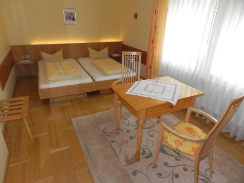 a small room with a bed and a table and a table and chairs at Gasthaus-Pension Zum Kreuz in Stühlingen