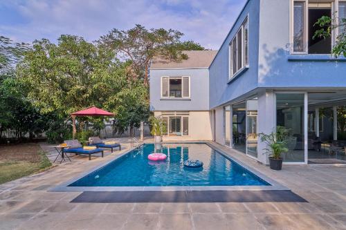 a swimming pool in the backyard of a house at SaffronStays Indigo House in Karjat