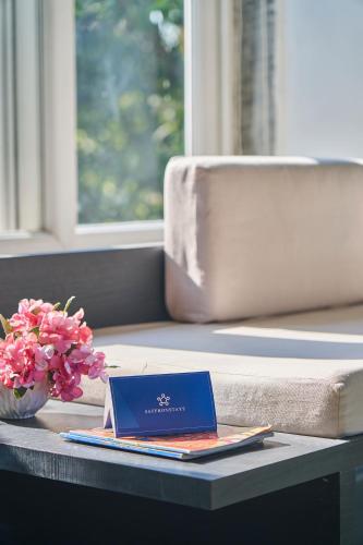 a book sitting on a table with a vase of flowers at SaffronStays Indigo House in Karjat