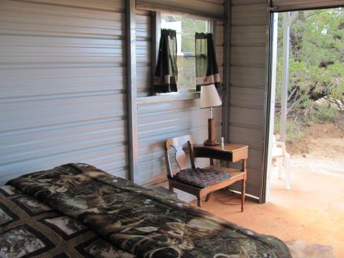 a bedroom with a bed and a desk and a chair at Lupine Cabin, Glamour Camping, Stunning Skies and Sunrise Views in Monticello