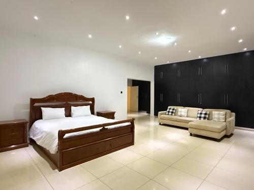 a large bedroom with a bed and a couch at Lonehill Ridge in Blantyre
