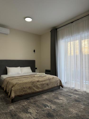 a bedroom with a bed and a large window at Grey Hotel in Oral