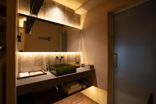 a bathroom with a green sink and a mirror at 燈やー弐 in Kyoto