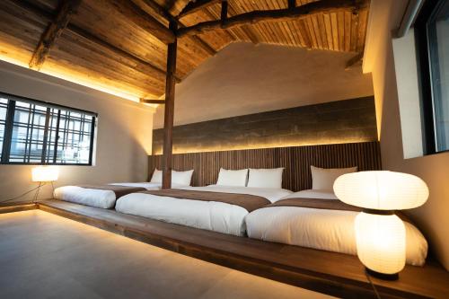 two beds in a room with two lamps at 燈やー弐 in Kyoto