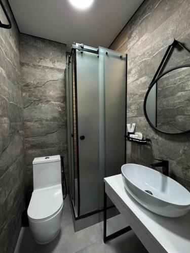 a bathroom with a sink and a toilet and a mirror at Grey Hotel in Oral