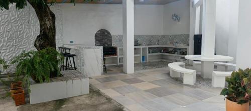 a room with white tables and benches and a tree at Casa Barcelona in Honda