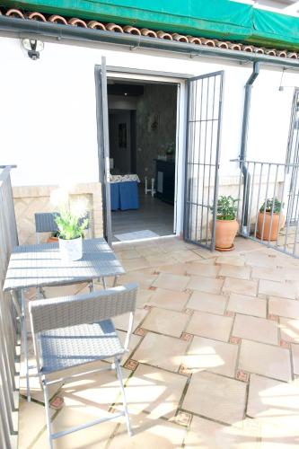 a patio with a table and chairs and an open door at Apartamentos Turisticos Ilusiones 2 in Cazalla de la Sierra