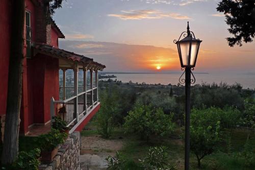 a street light next to a building with the sunset in the background at Sea View Villa with 4 bedrooms - grECOrama in Monodhéndrion