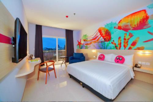a bedroom with a bed with a fish mural on the wall at favehotel Bitung in Bitung