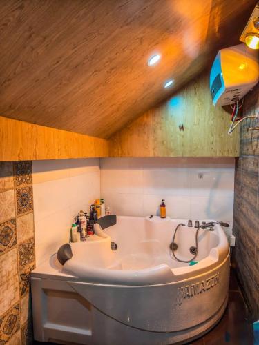 a bath tub in a bathroom with a wooden ceiling at Oáza coffee & bar in Hanoi