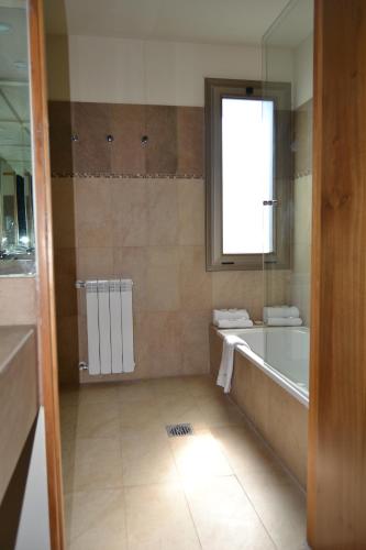 a bathroom with a tub and a sink and a bath tub at Plaza Paradiso Petit Hotel in Chacras de Coria