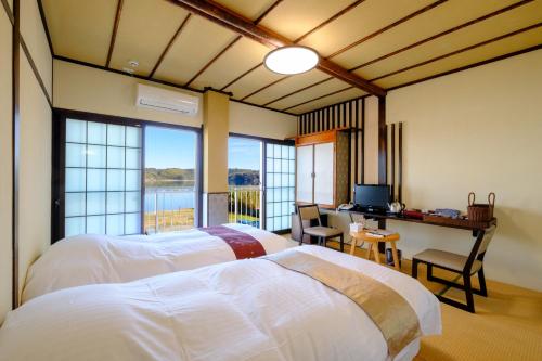 a bedroom with two beds and a desk with a computer at 鹿鳴館 in Yurihama