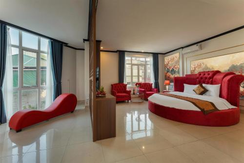 a bedroom with a large red bed and red chairs at Royal Hotel & Spa in Ðồng Ky