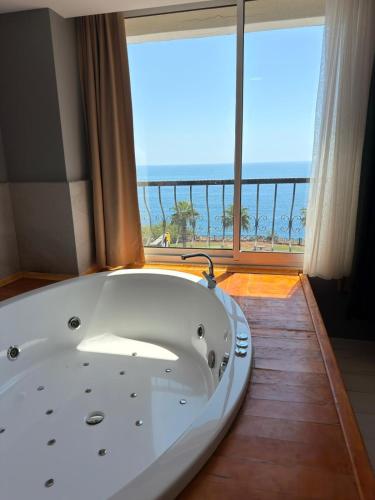 a bath tub in a room with a large window at On Hotel in Antalya
