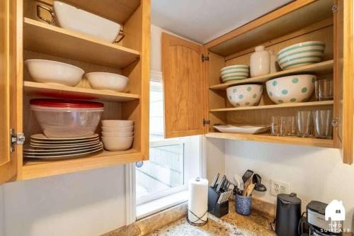 a kitchen with wooden cabinets with plates and bowls at Cozy Charming Richmond 1BR Retreat in San Francisco
