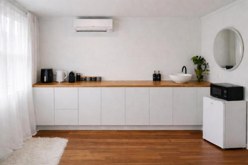 a kitchen with white cabinets and a counter with a sink at Blagdon Close Guesthouse in New Plymouth