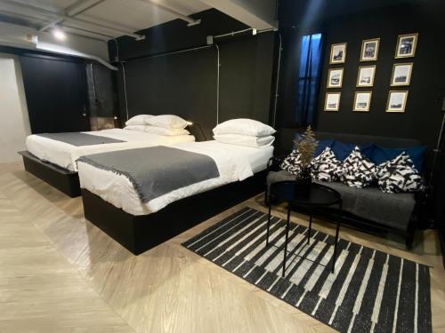 a bedroom with two beds and a couch at Bedsment in Chiang Rai