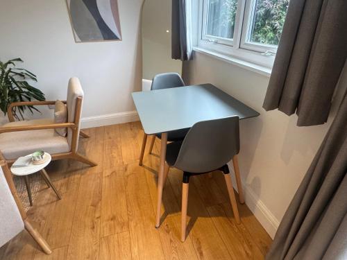 a table and chairs in a room with a window at Cosy cabin nestled in the Surrey Hills in Dorking
