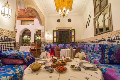 a room with couches and a table with food on it at Riad Jardin Chrifa in Fès
