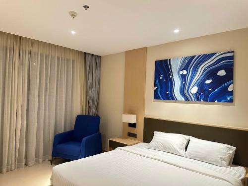 a bedroom with a bed and a blue chair at Arena Oceanview Cam Ranh - Infinity swimming pool in Cam Ranh International Airport