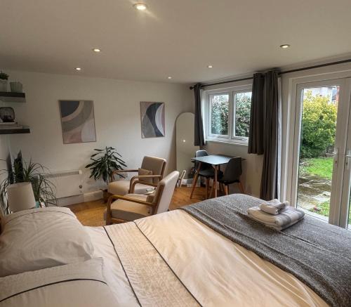 a bedroom with a bed and a table and chairs at Cosy cabin nestled in the Surrey Hills in Dorking