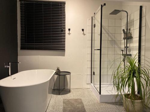 a bathroom with a tub and a glass shower at Bedsment in Chiang Rai