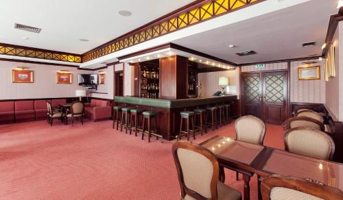 un restaurant avec un bar, des tables et des chaises dans l'établissement Hotel Lux Mundi, à Fátima