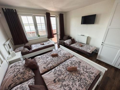 a living room with four beds and a couch at Penzion Šedivý in Strachotín