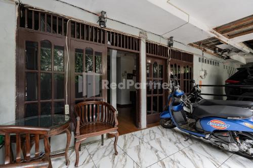 a motor scooter parked in a room with a table at Danysa Guest House Jakarta RedPartner in Jakarta