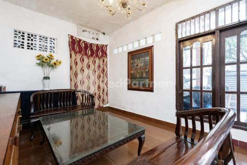 a living room with a table and chairs and windows at Danysa Guest House Jakarta RedPartner in Jakarta