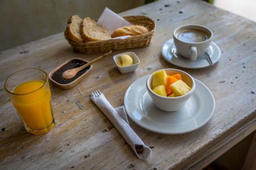 een tafel met een kopje sinaasappelsap en een schaal fruit bij Niños Hotel Fierro in Cuzco