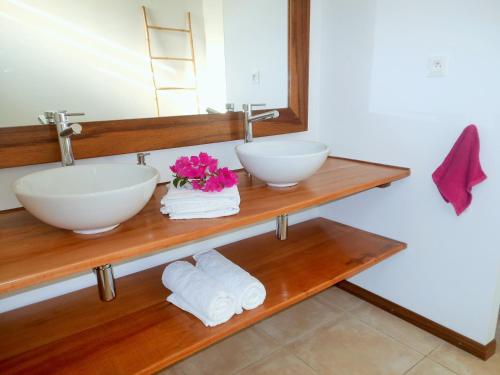 a bathroom with two sinks and towels and a mirror at Le Pic De La Buse in Les Anses-dʼArlets